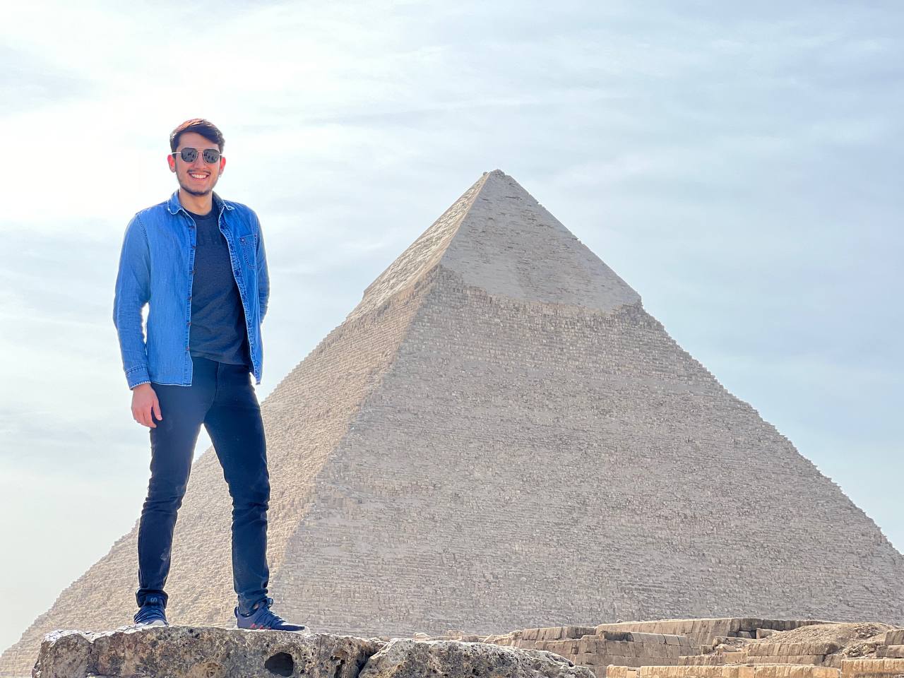 a person standing in front of the great pyramid of Giza