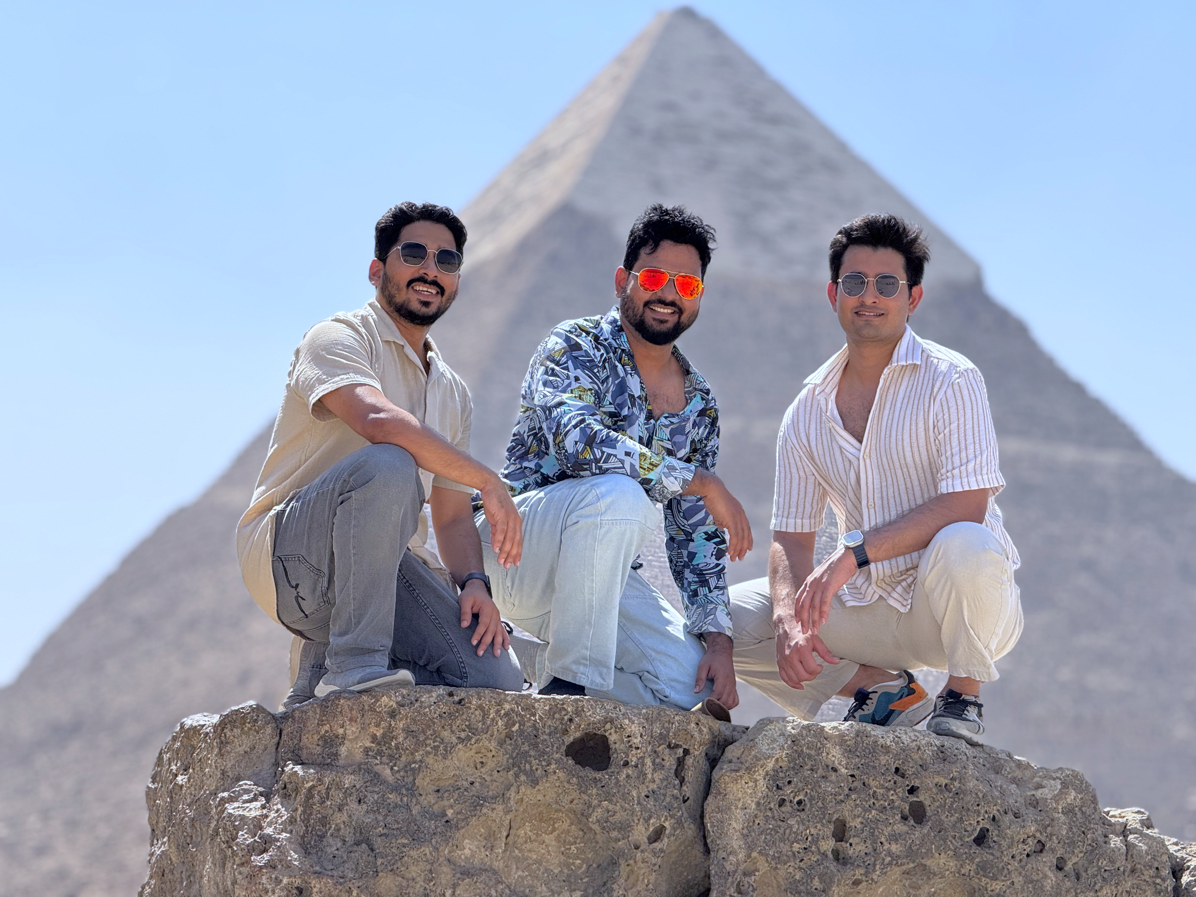 a group of 3 men in front of the great pyramid of Giza