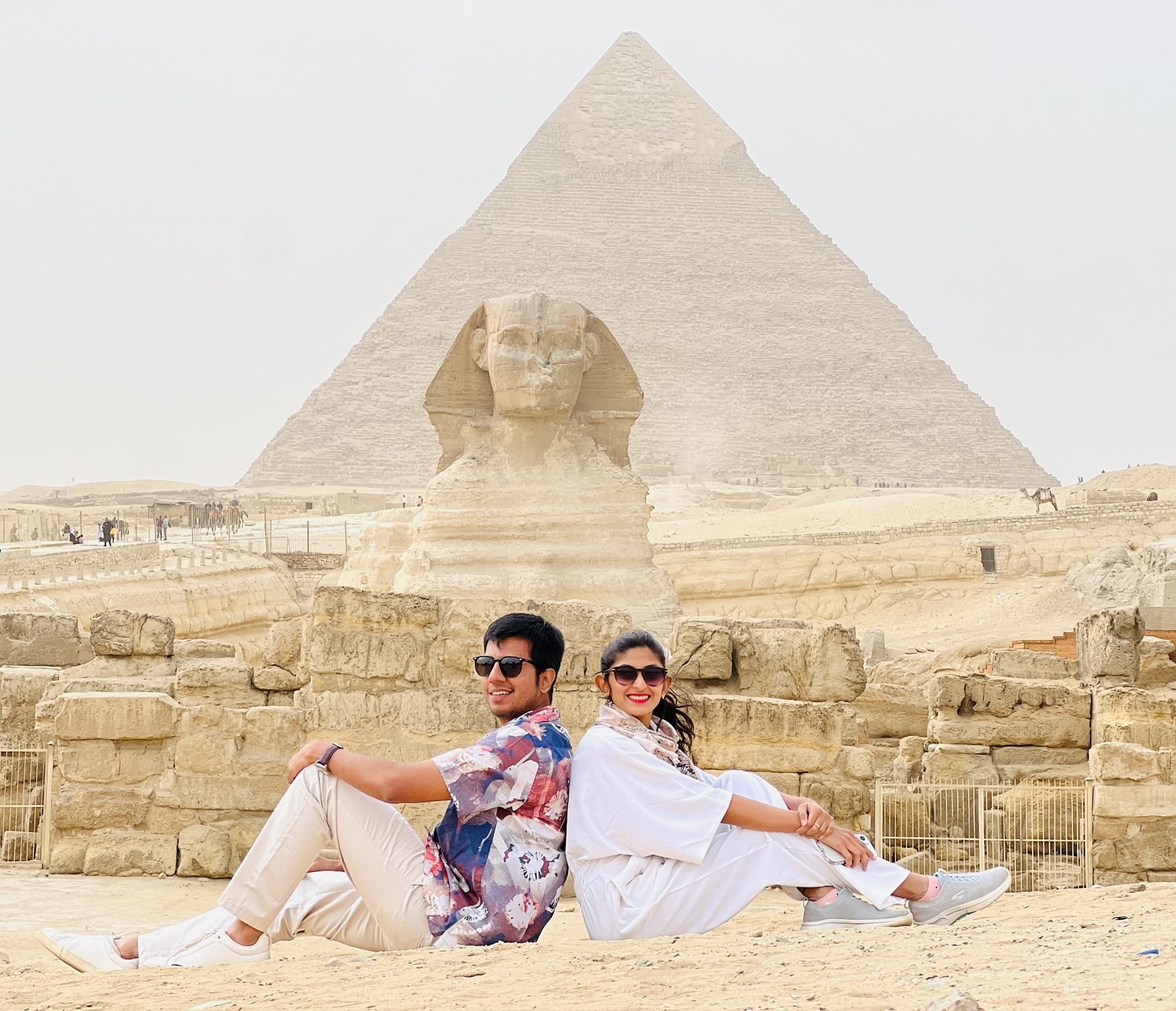 a couple taking picture in front of sphinx