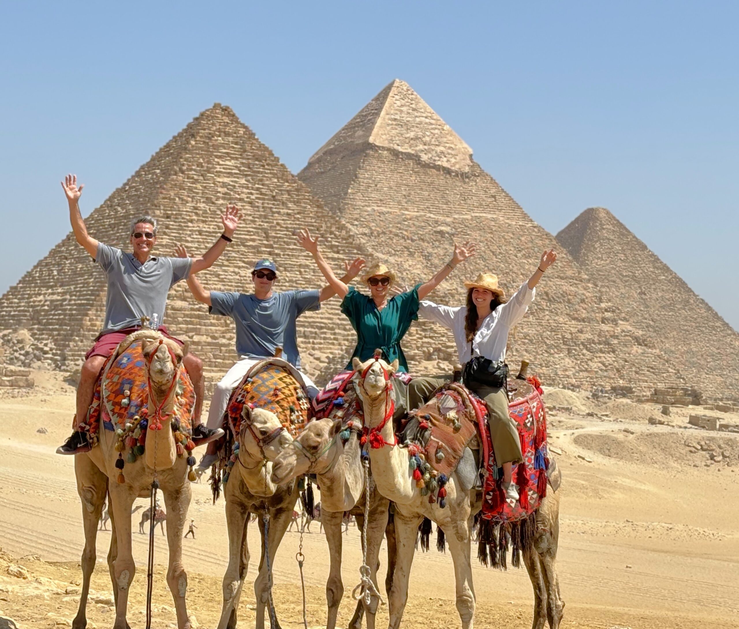 a group tour riding camels in Giza pyramids