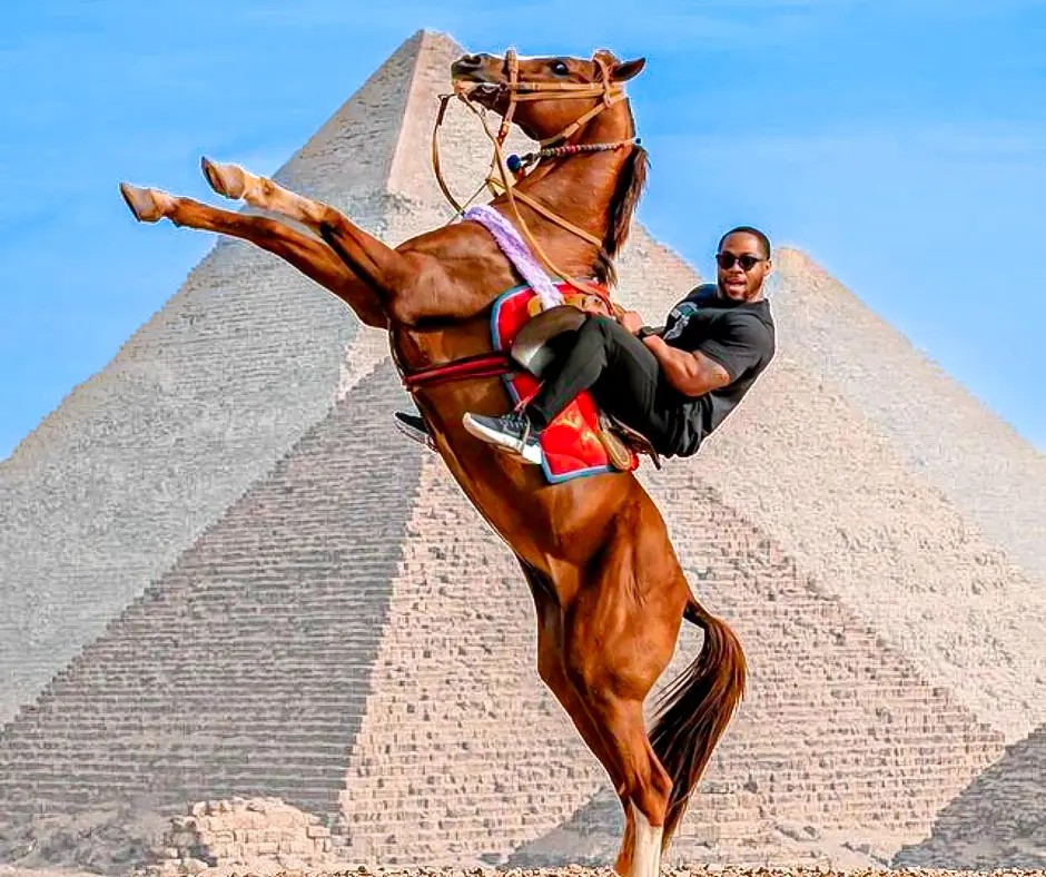 a person riding horse in front of Pyramids